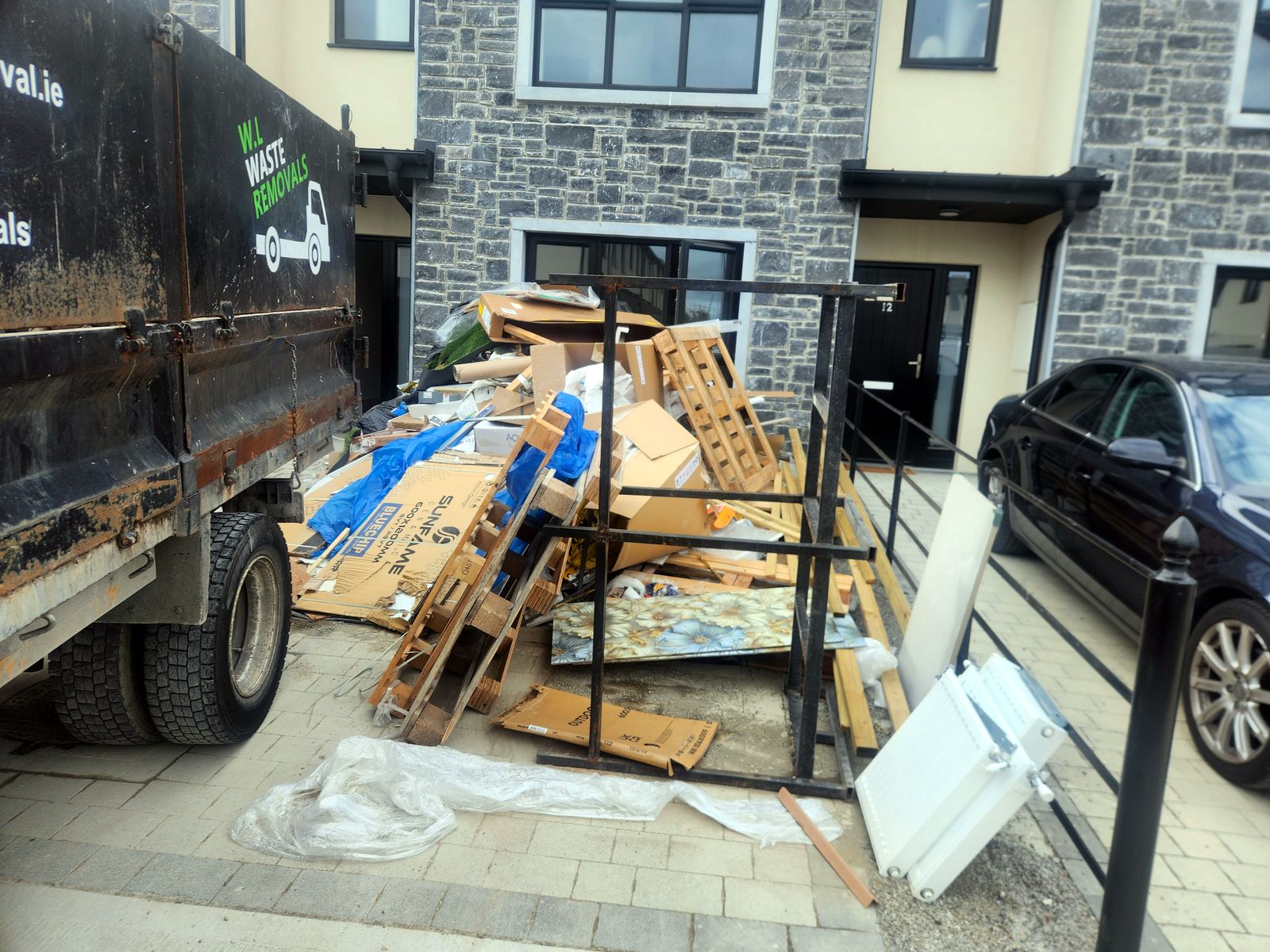Pallets, cardboard and packaging piled outside the front of a house