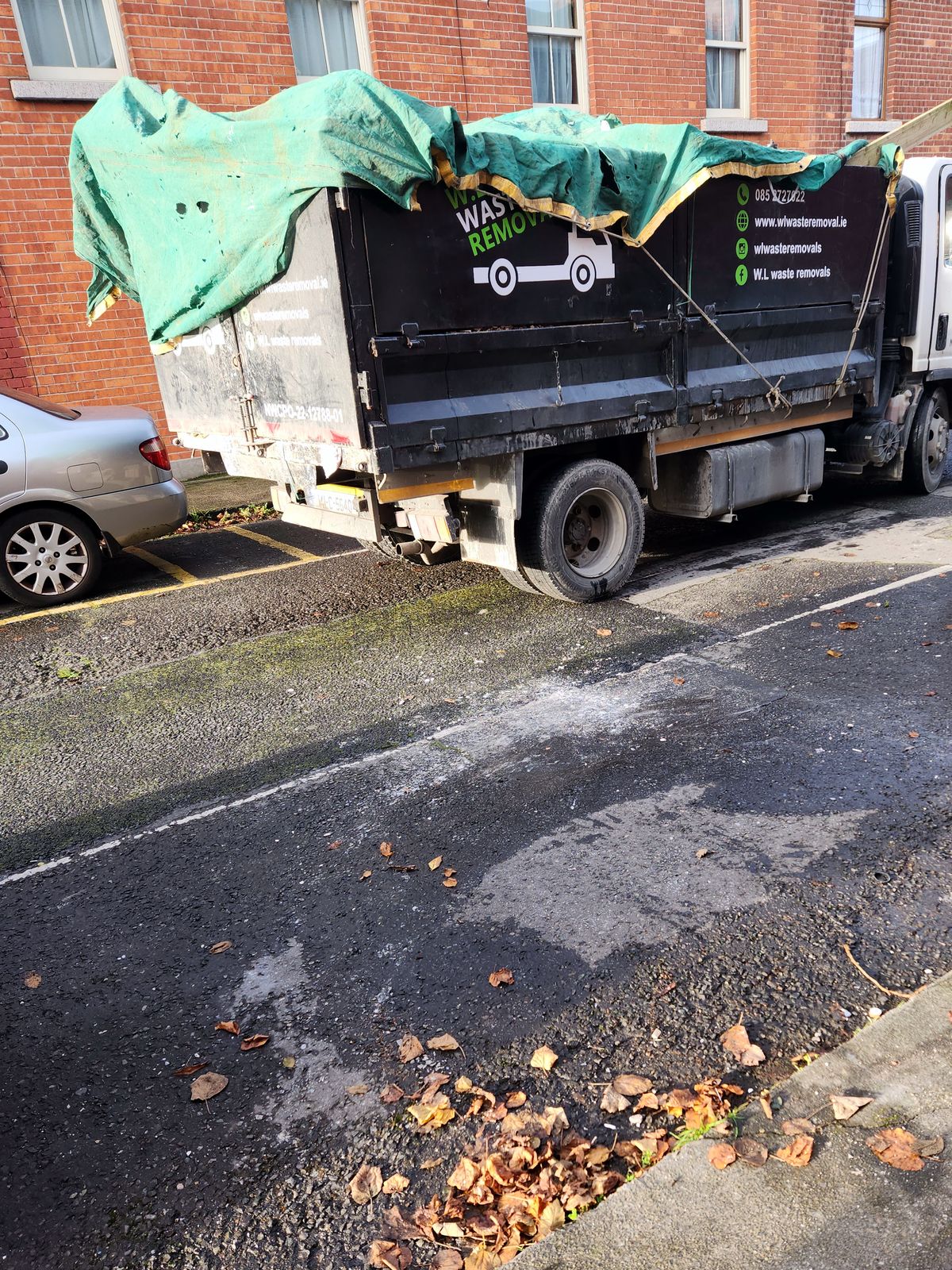 Loaded tipper truck under a tarp on a Dublin street after a clearance